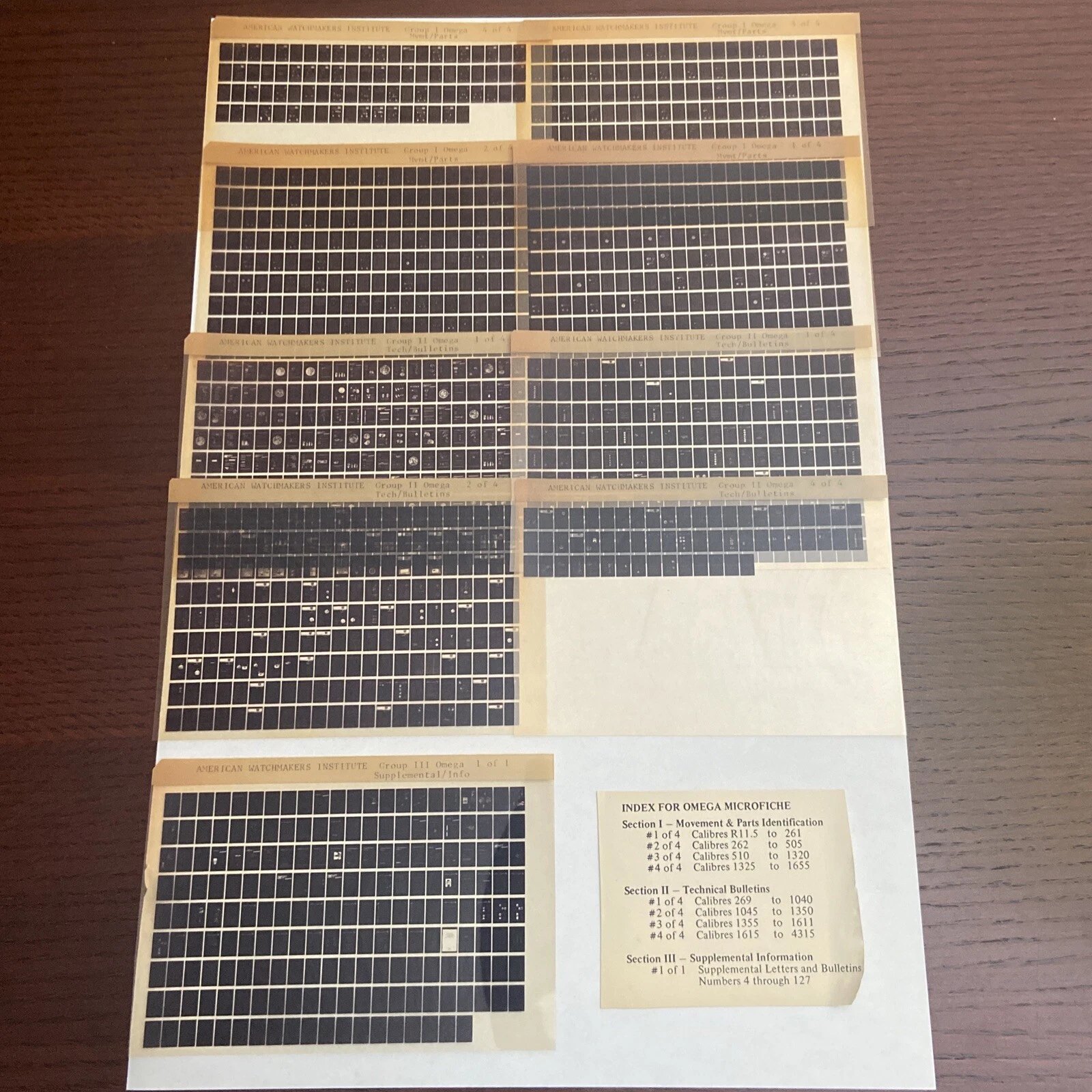 The nine AWI Omega microfiche sheets laid out with their index card